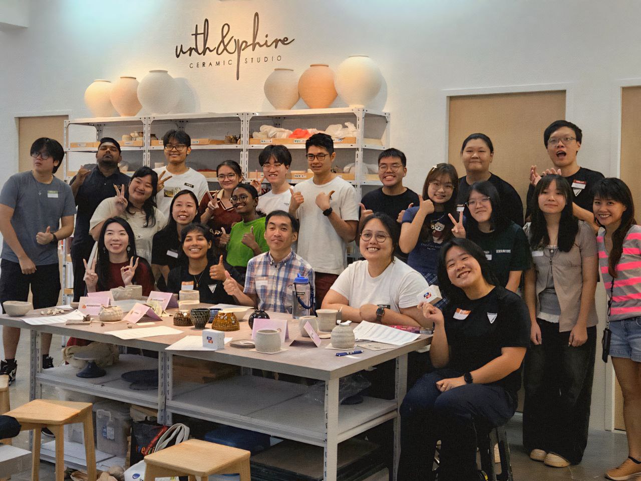 Corporate team posing after a fun pottery team-building workshop at Urth & Phire Ceramic Studio in Singapore