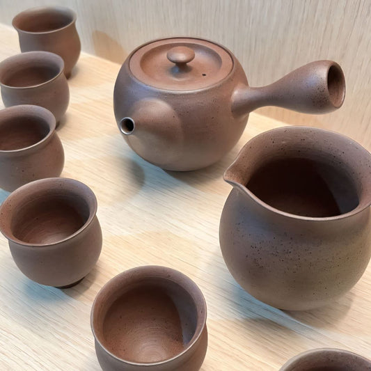Close-up of lidded pot with spout and tea set made on pottery wheel in advanced pottery class