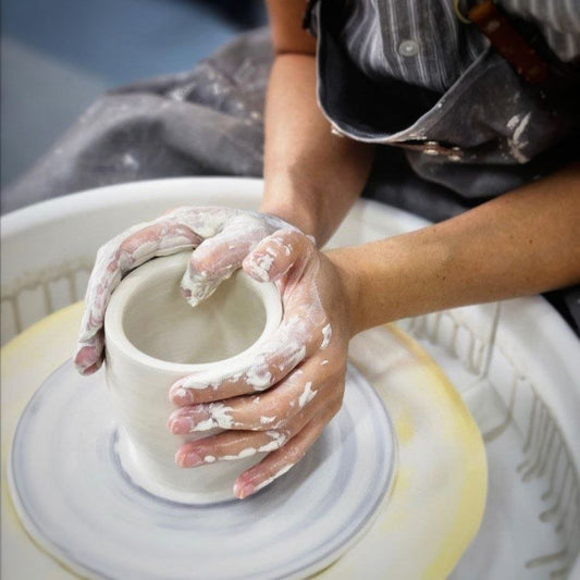 Student shaping clay on pottery wheel during beginner class at Urth & Phire Ceramic Studio