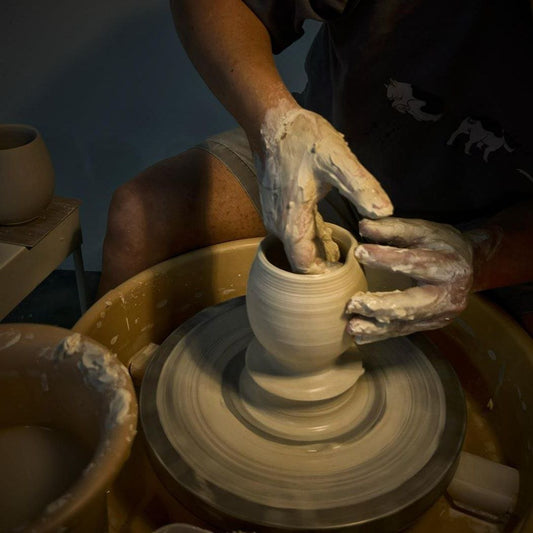 Ceramic maker forming pottery on potter's wheel in open studio access session